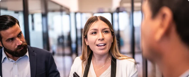 Young businesswoman talking with her coworkers at office corridor