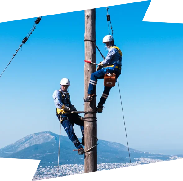 two men working at the top of an electric pylon