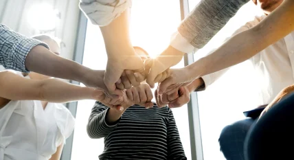 Close up top view of young and freshness energy business people putting their strong hands together. Stack of friendship hands. Unity and successful teamwork concept