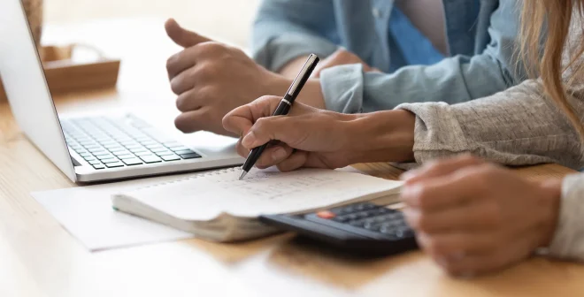 Close up spouses calculating family budget paying online using laptop