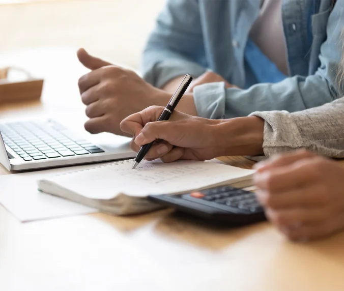 Close up spouses calculating family budget paying online using laptop