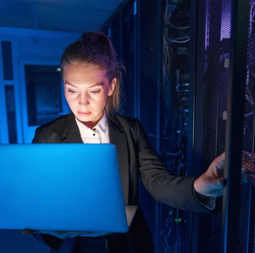 System technician using laptop to analyze server