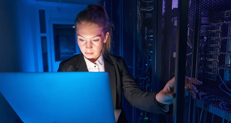System technician using laptop to analyze server