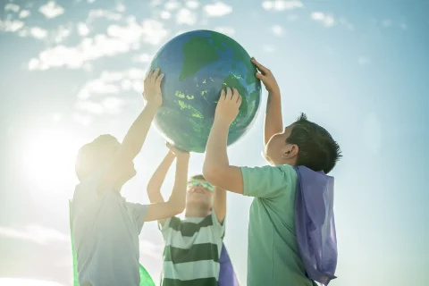 Boys holding an earth sphere at the beach