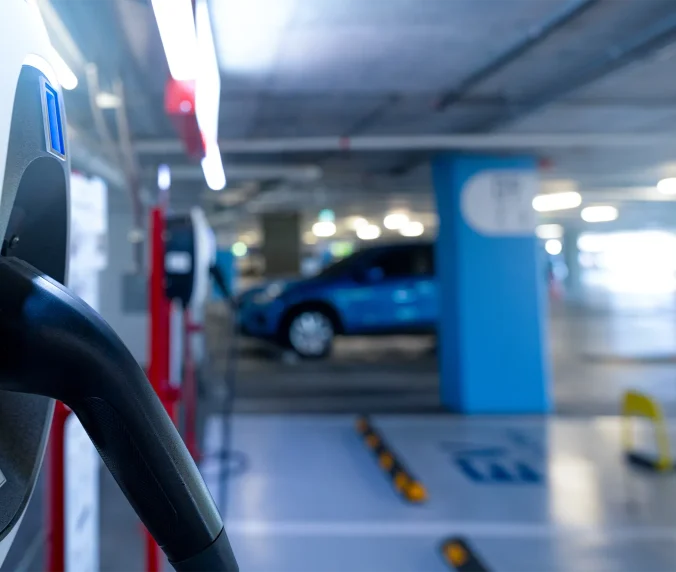 Electric car charging station for charge EV battery. Plug for electric vehicle. EV charger. Charging point at car parking lot of the mall. Clean and sustainable energy. Commercial EV charging point