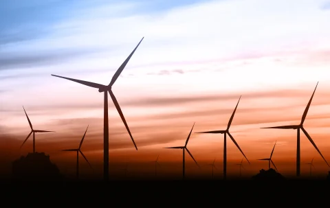 Beautiful landscape image with Windturbine farm at the sunset