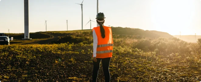 Female worker walking towards car in wind power field