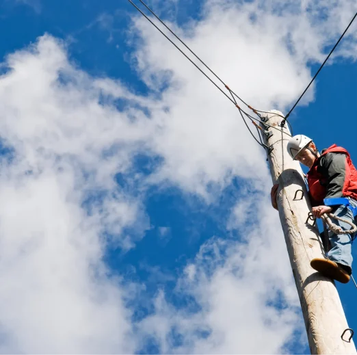 A man working at the top of an electric pylon
